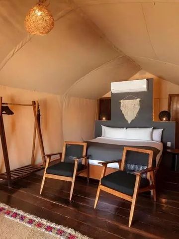 Gemütliches Zeltzimmer mit Doppelbett und stilvollen Holzmöbeln