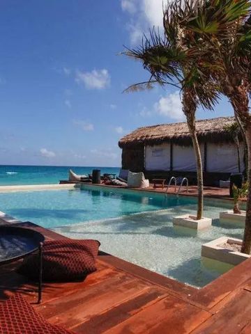 Infinity Pool am Strand mit Palmen und Liegestühlen