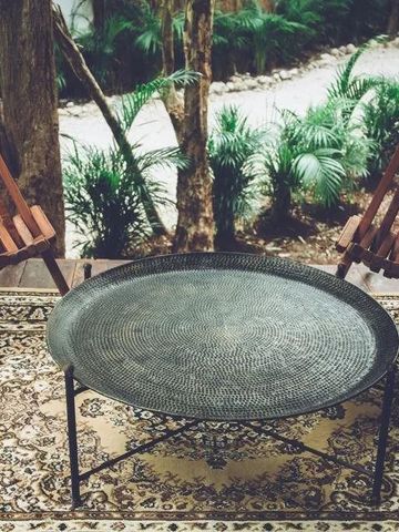 Gemütliche Sitzecke im Freien mit Teppich und Holzmöbeln