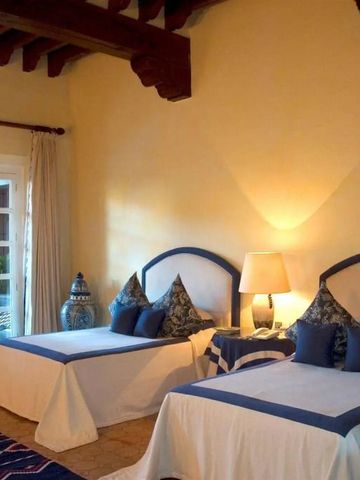 Helles Gästezimmer mit zwei Betten in blauen Akzenten und schmuckem Dekor