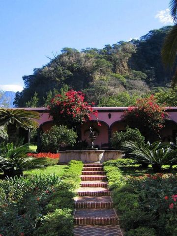 Üppiger Garten mit gepflegten Beeten und charmantem Pfad zu einem Springbrunnen