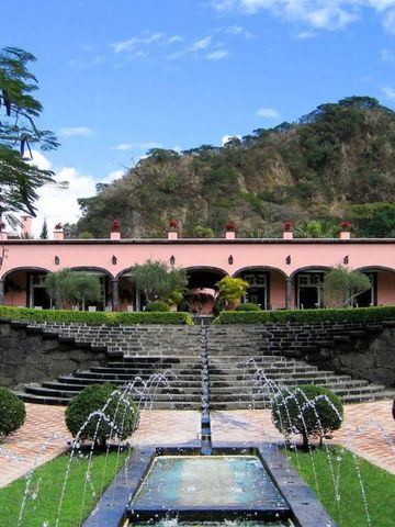 Prächtige Gartenanlage mit Springbrunnen vor einer pittoresken Hügellandschaft