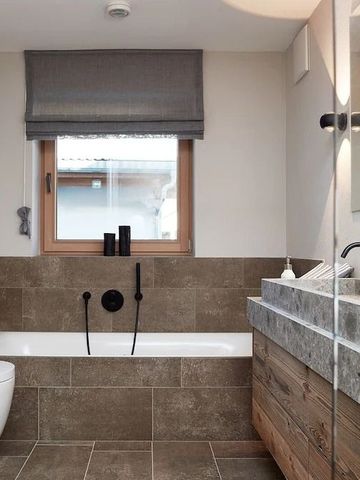 Modernes Badezimmer mit Badewanne, Holzverkleidung und großem Spiegel