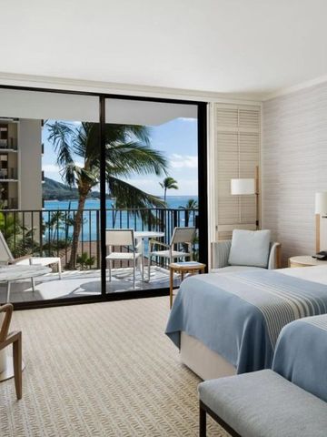 Gemütliches Hotelzimmer mit Doppelbetten und Blick auf den Ozean