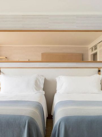 Doppelzimmer mit zwei Einzelbetten und großem Wandspiegel