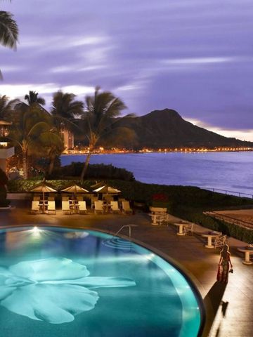 Hotelpool bei Dämmerung mit Blick auf das Meer und Palmen