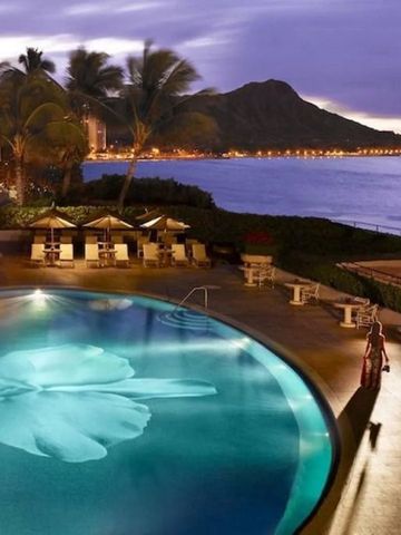 Hotelpool bei Abenddämmerung mit traumhaftem Meerblick und Palmen