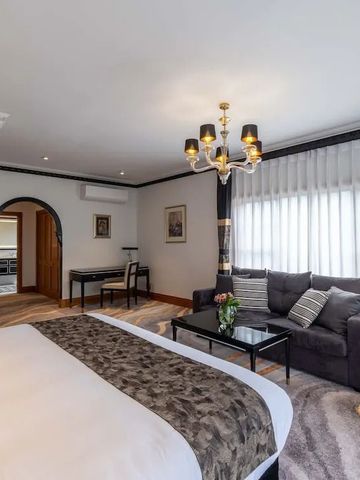Elegantes Hotelzimmer mit Doppelbett, Sofa und einem Kronleuchter