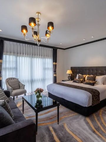 Geräumiges Zimmer mit komfortablem Bett und Sofabereich unter einem Kronleuchter