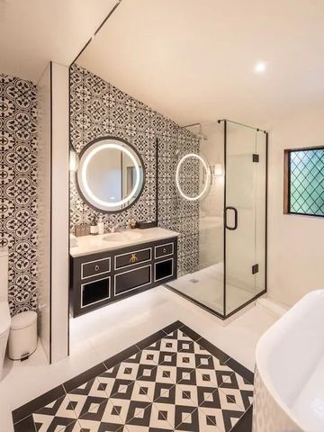 Modernes Badezimmer mit dekorativen Fliesen und Glasdusche.