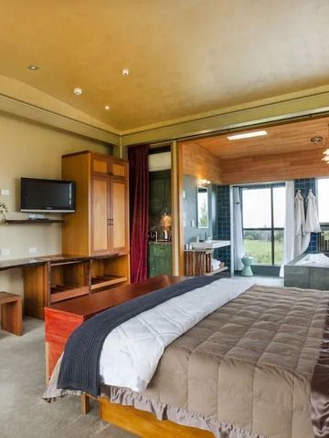 Luxuriöses Zimmer mit Holzdetails und großer Fensterfront mit Blick auf die Landschaft