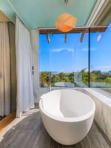Moderne Badewanne mit Panoramafenstern und Blick auf die Natur