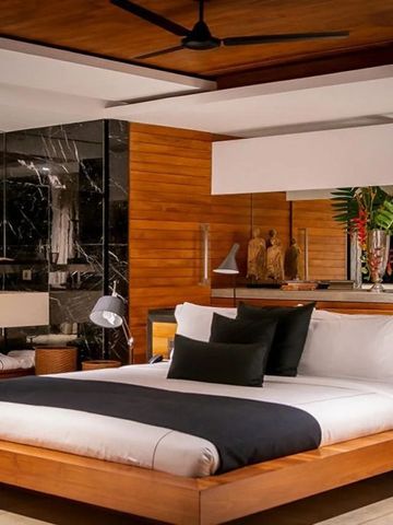 Schickes Schlafzimmer mit modernen Holzmöbeln und Dekor