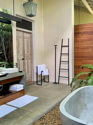 Luxuriöses Badezimmer mit freistehender Badewanne und Pflanzen.