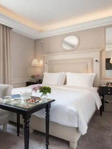 Helles Hotelzimmer mit weißem Doppelbett und Spiegel