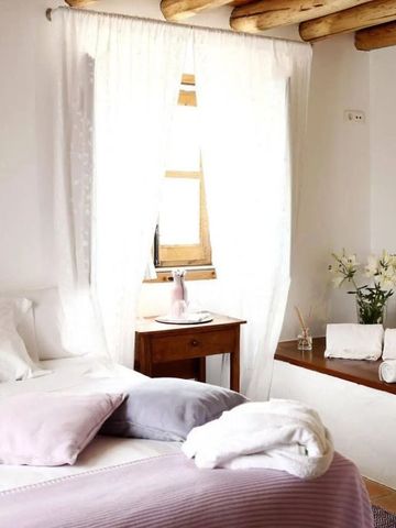 Gemütliches Zimmer mit hellem Dekor und Fenster mit Vorhängen