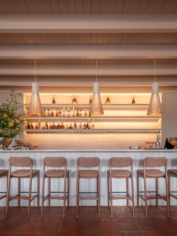 Moderne Hotelbar mit stilvoller Beleuchtung und Barhockern