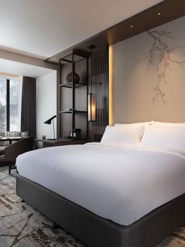 Hotelzimmer mit großem Bett und dekorativer Wandkunst