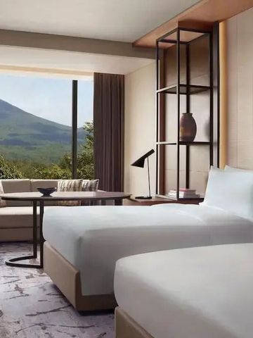 Hotelzimmer mit zwei Einzelbetten und großem Fenster zum Berg