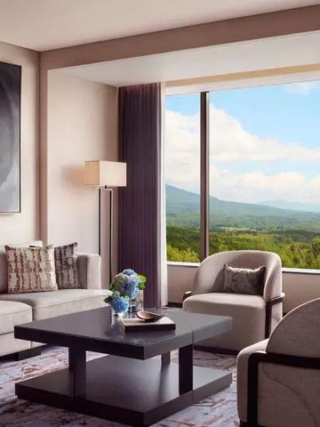 Suite mit gemütlicher Sitzecke und Panoramablick auf die Natur