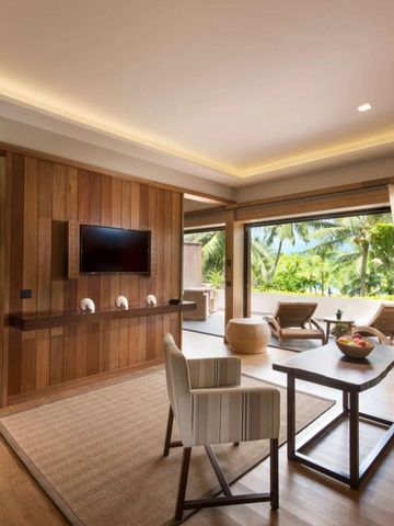 Elegante Suite mit Holzverkleidung und Aussicht auf tropische Vegetation