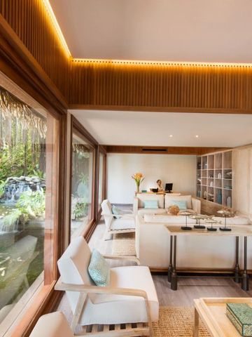 Helle Lounge mit Panoramablick auf Wasserfall und Natur