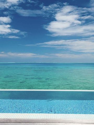 Infinity-Pool mit Blick auf den Ozean und blauem Himmel