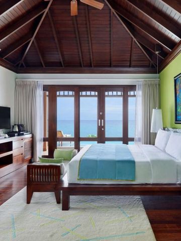Luxuriöses Schlafzimmer mit hohen Decken und Meerblick im Resort auf den Seychellen