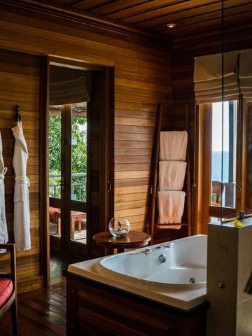 Luxuriöses Badezimmer mit Holzverkleidung und Whirlpool im Resort auf den Seychellen