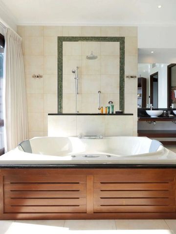 Modernes Badezimmer mit geräumiger Badewanne und zwei Waschbecken im Hilton Seychelles Northolme Resort