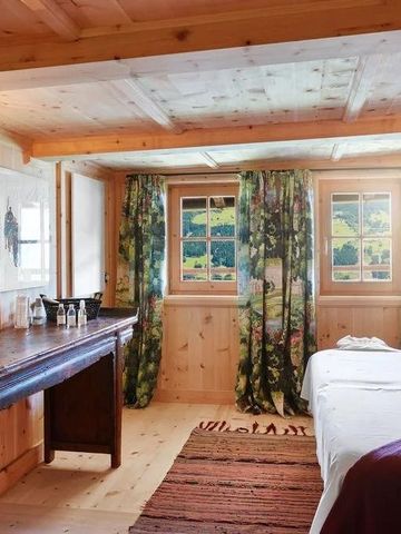 Wellnessraum im Chalet mit Massageliege und rustikaler Holzverkleidung