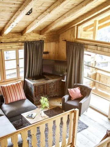 Einladendes Wohnzimmer im Chalet-Stil mit Kamin und Panoramafenstern