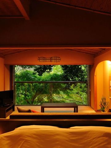 Warmer, traditionell eingerichteter Raum mit großem Fenster und Blick auf einen grünen Garten