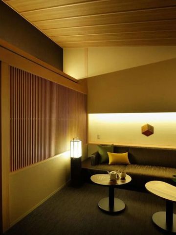 Modern eingerichtetes Hotelzimmer mit Sitzecke und stimmungsvoller Beleuchtung