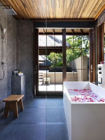 Elegantes Badezimmer mit moderner Badewanne und Dschungelblick