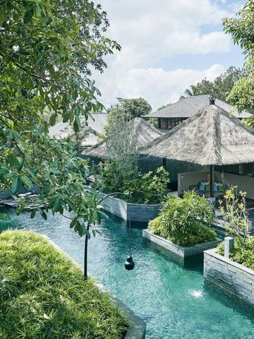 Ausblick auf Villen mit Strohdächern und Wasserwegen im HOSHINOYA Bali