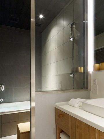 Modernes Badezimmer mit Badewanne und großer Spiegelwand