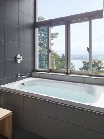 Modernes Badezimmer mit Badewanne und Ausblick auf die Berge