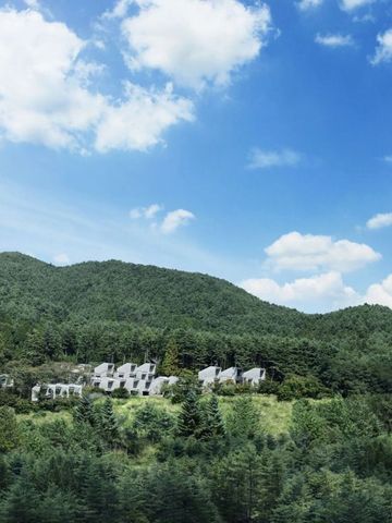 Grüne Hügel mit modernen Gebäuden unter blauem Himmel