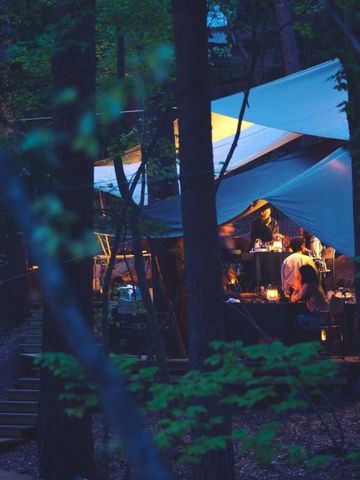 Beleuchtetes Zelt im Wald in der Dämmerung