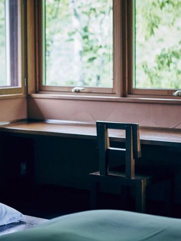 Arbeitsbereich mit Fensterblick ins Grüne in einem Hotelzimmer