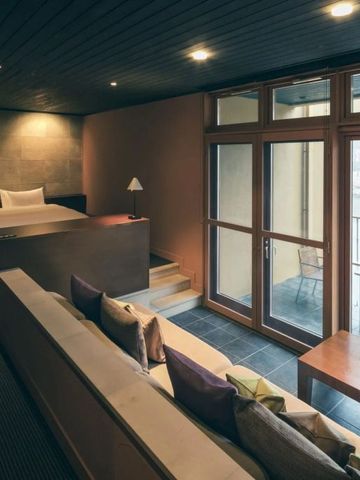 Gemütliches Hotelzimmer mit Sitzecke und Zugang zum Balkon