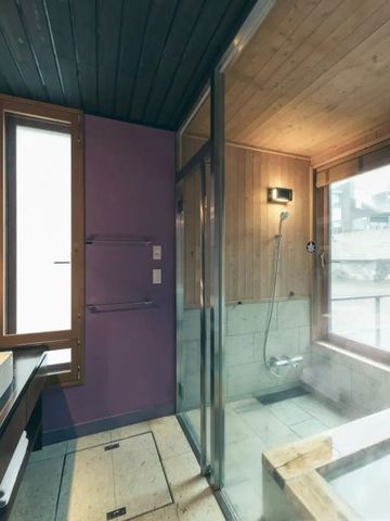 Modernes Badezimmer mit Glasdusche und großem Fenster.
