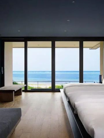 Geräumiges Zimmer mit moderner Einrichtung und Panoramablick aufs Meer.