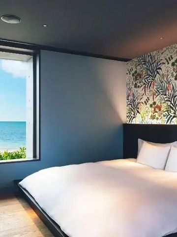 Zimmer mit großem Fenster zum Meer. Helle, moderne Einrichtung.