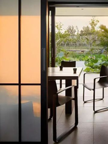 Zimmer mit Schiebetür und Blick auf eine Terrasse mit Garten