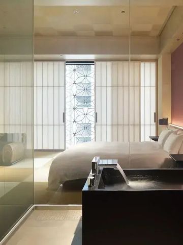 Luxuriöses Schlafzimmer mit Glaswand und stilvollem Interieur.