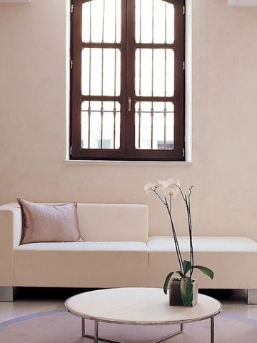 Helles Lounge-Zimmer mit Sofa und Tisch vor einem Fenster