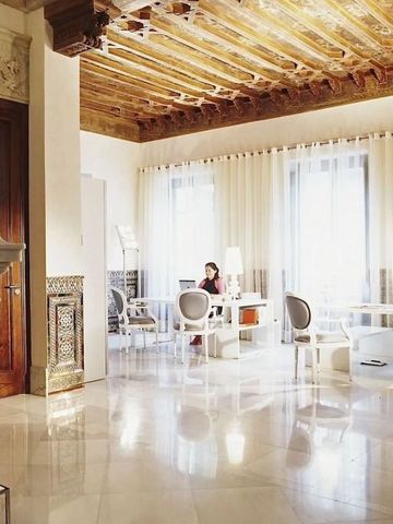 Eleganter Raum mit historischen Decken und weißen Möbeln