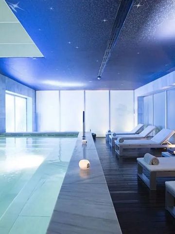 Beleuchteter Indoor-Pool mit Liegeflächen, blauem Sternenhimmel